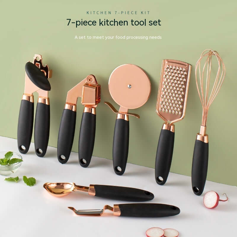 7-piece kitchen utensil set with black and gold handles including can opener, garlic press, pizza cutter, grater, whisk, ice cream scoop, and peeler, displayed on a clean green and white background.