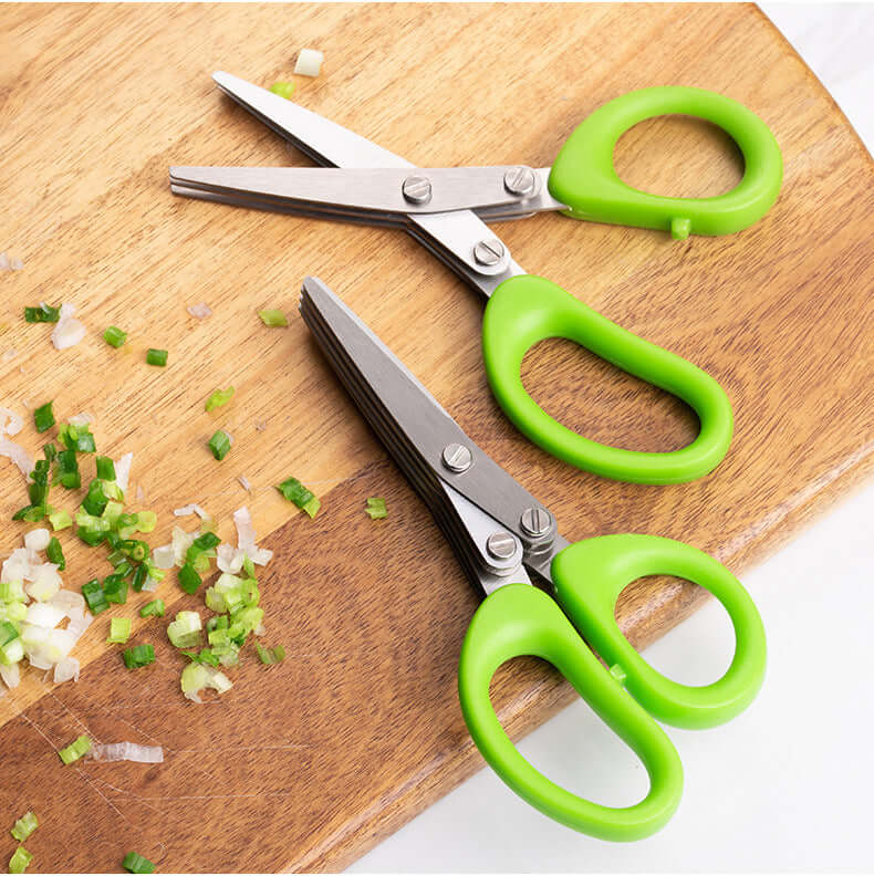 Multi-blade kitchen herb scissors with green handles on a cutting board with chopped scallions