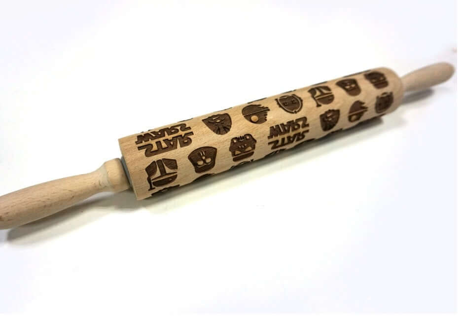 Wooden embossed rolling pin with character and text pattern for baking on white background