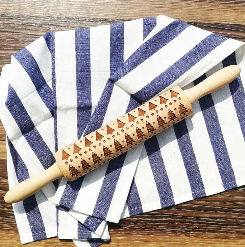 Christmas tree engraved wooden rolling pin on striped kitchen towel