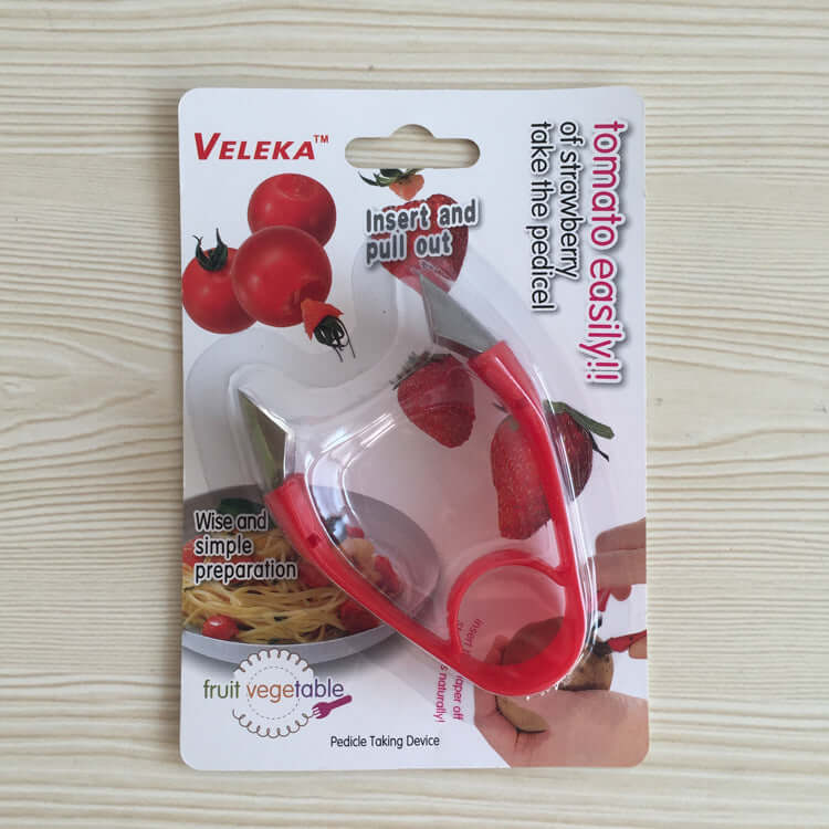 Tomato and strawberry corer kitchen tool with red handle in retail packaging on wood surface