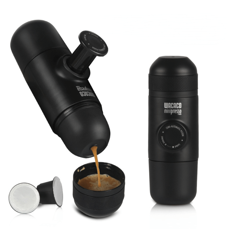 Portable manual espresso maker with coffee pouring into cup, black design, kitchen gadget