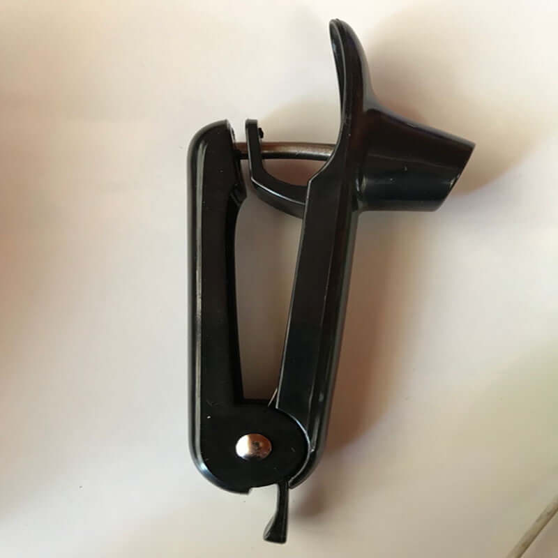 Black plastic cherry pitter kitchen utensil on white background