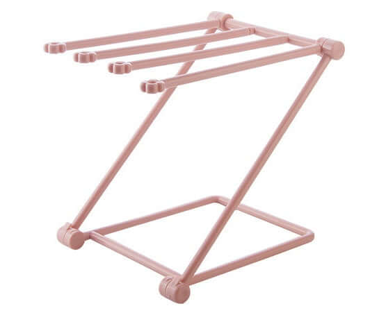 Pink plastic kitchen lid organizer rack with four slots, countertop storage accessory