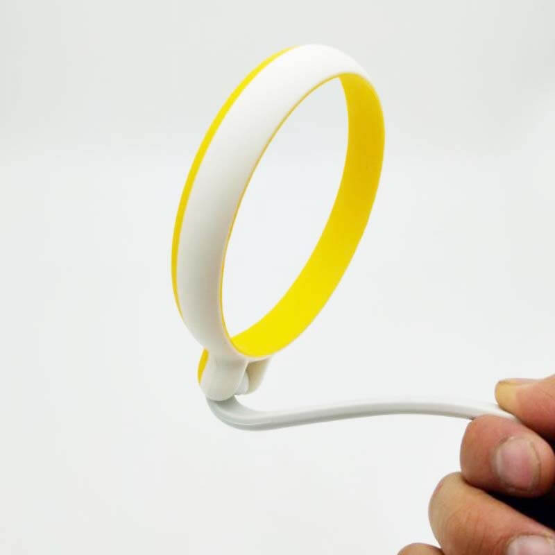 Hand holding yellow and white kitchen utensil with circular handle, kitchen accessory