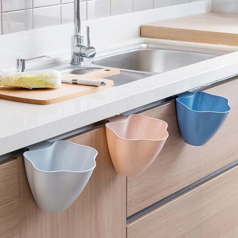 Set of hanging kitchen trash bins in blue, beige, and gray on a modern countertop