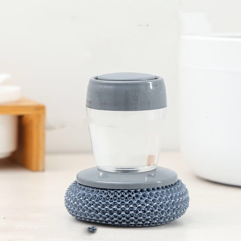 Gray dish scrubber with soap dispenser on a kitchen counter