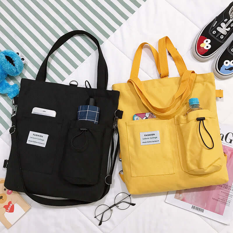 Black and yellow canvas tote bags with multiple pockets holding phone, bottle, and glasses