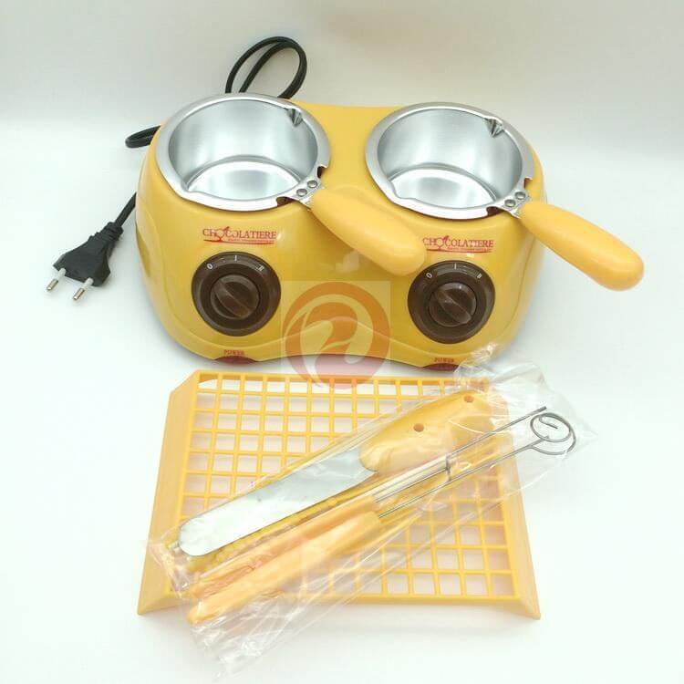 Yellow electric chocolate melting pot with two pans, spatula, fork, and grid tray for kitchen use