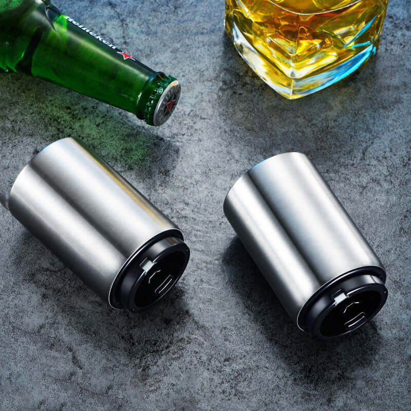 Stainless steel bottle openers on a countertop with a beer and whiskey glass