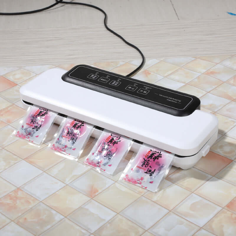Kitchen vacuum sealer sealing multiple food bags on countertop