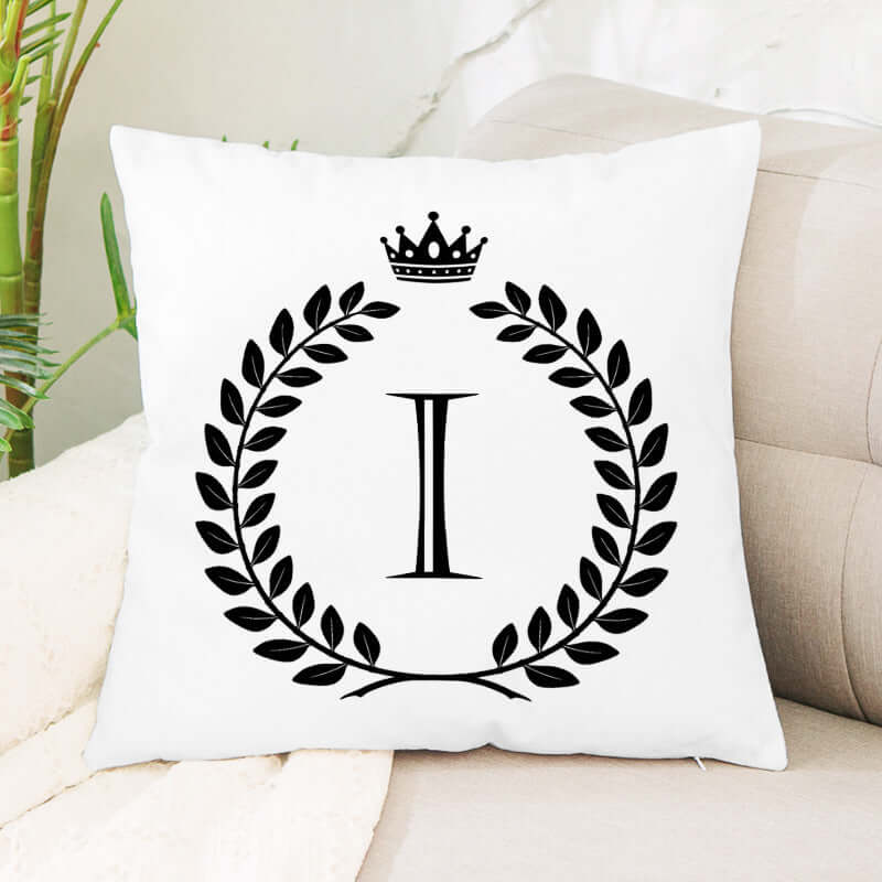 White decorative throw pillow with black laurel wreath, crown, and Roman numeral I design