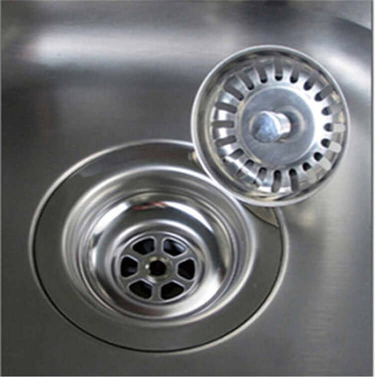 Stainless steel kitchen sink with removable strainer basket and drain stopper.