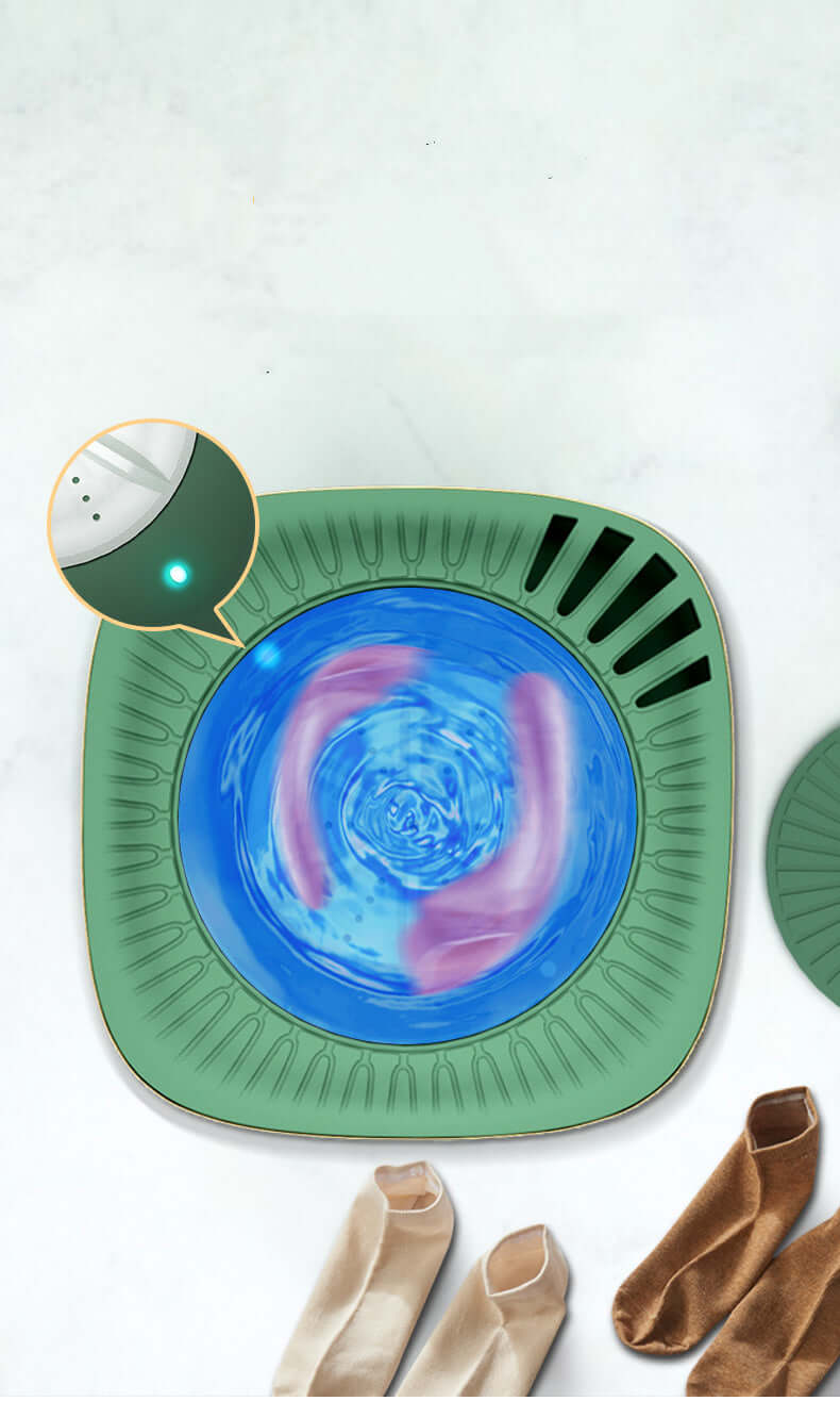 Mini portable washing machine with water swirling inside, washing socks on a marble surface.