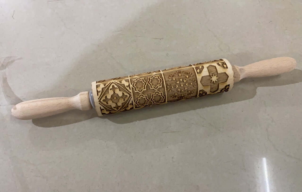 Wooden embossed rolling pin with decorative patterns for baking on a kitchen counter