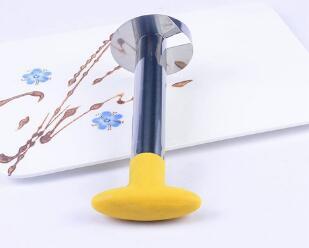 Stainless steel kitchen tool with yellow handle on white floral background