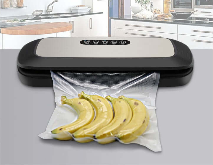 Vacuum sealer machine sealing fresh bananas in plastic bag on modern kitchen counter