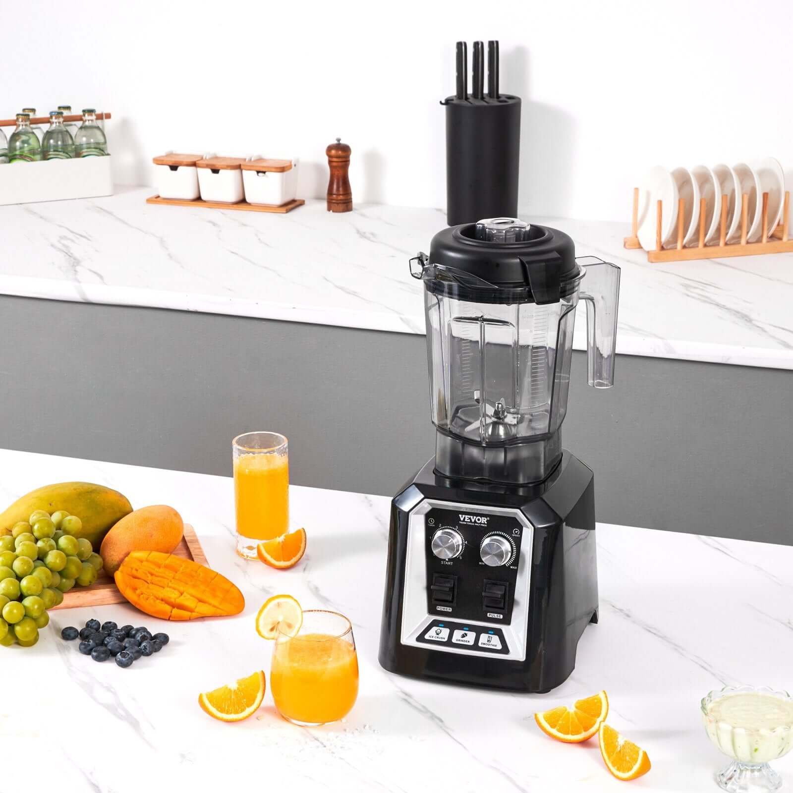 Black countertop blender with fruit and juice on a modern kitchen counter