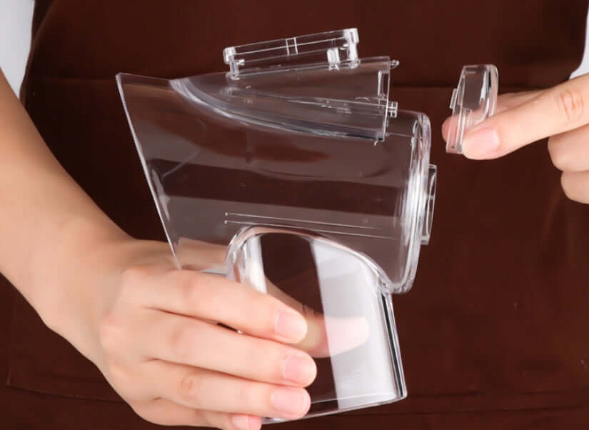 Hands holding a clear plastic kitchen tool part with removable cover