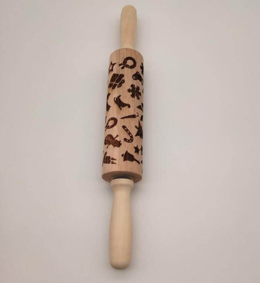 Wooden embossed rolling pin with festive holiday patterns on white background