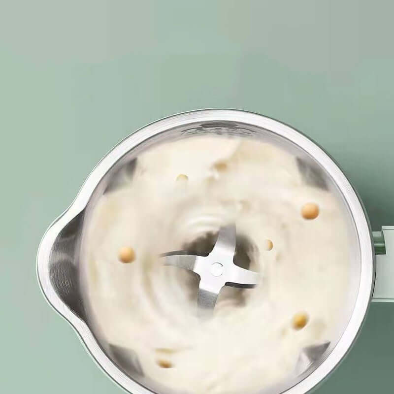 Overhead view of a blender with stainless steel blades mixing soybeans and liquid