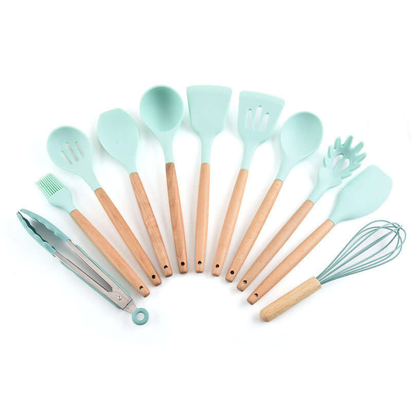 Set of mint green silicone kitchen utensils with wooden handles on white background