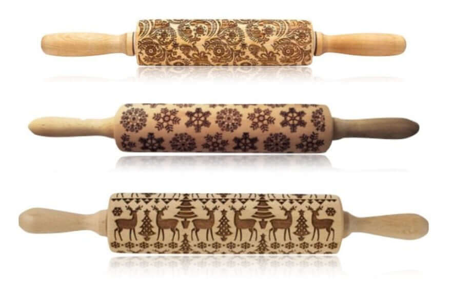 Set of three engraved wooden rolling pins with floral, snowflake, and reindeer patterns for baking.