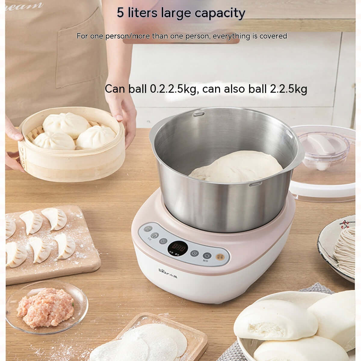 5 liter stand mixer with dough in stainless steel bowl, surrounded by buns and dumpling ingredients on kitchen table.