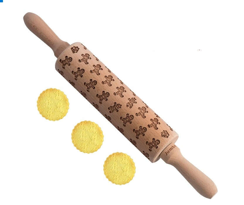 Embossed gingerbread man rolling pin with three decorated cookies on white background