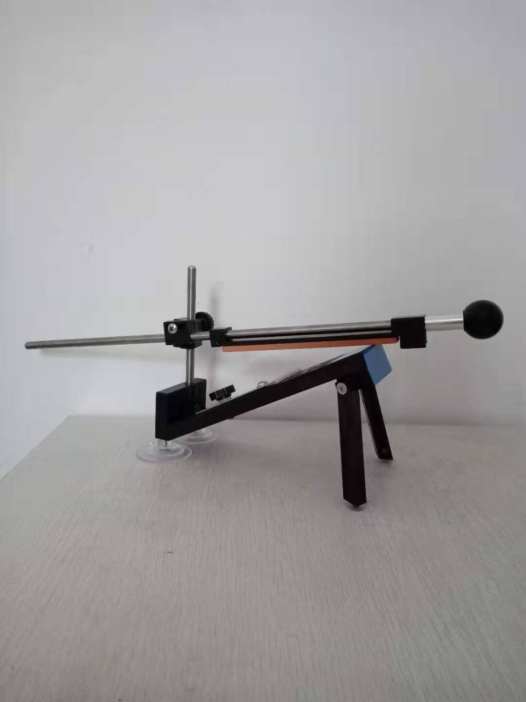 Manual kitchen knife sharpener tool with adjustable angle on table