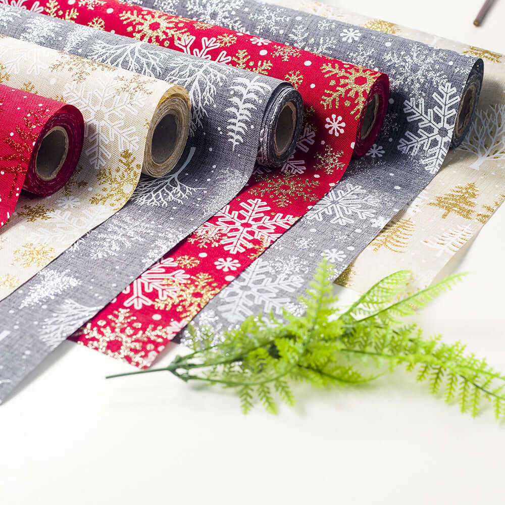 Christmas-themed fabric rolls with snowflake patterns in red, gray, and beige colors