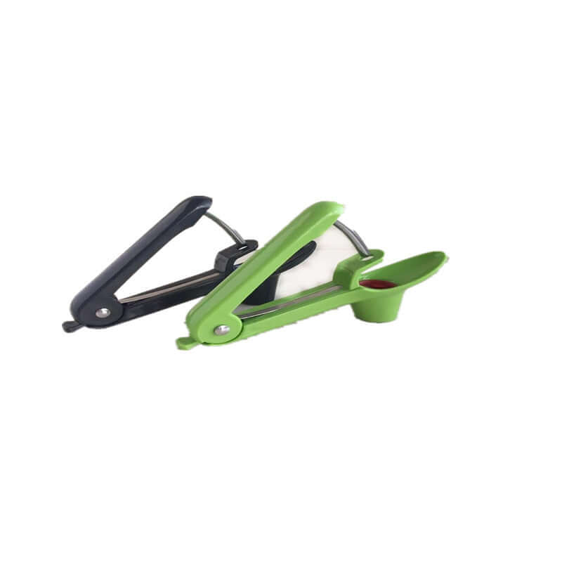 Green and black handheld cherry pitter kitchen tool on white background