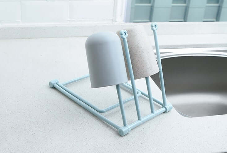 Blue cup drying rack with drying cups on kitchen countertop beside sink