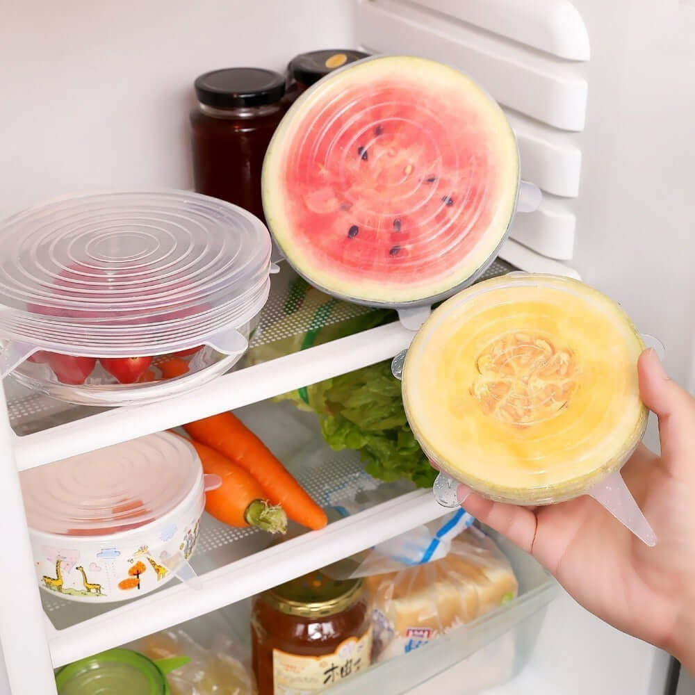 Reusable silicone stretch lids covering cut fruit and bowls in refrigerator