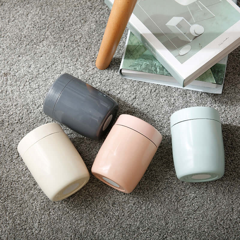 Set of four pastel-colored kitchen storage containers on a carpeted floor