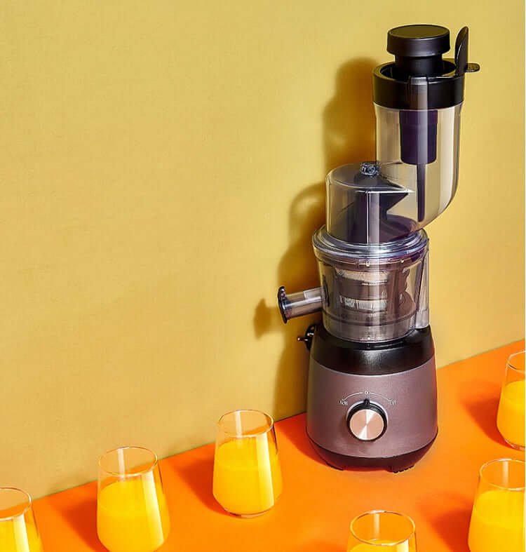 Electric juicer machine with fresh orange juice glasses on orange and yellow background