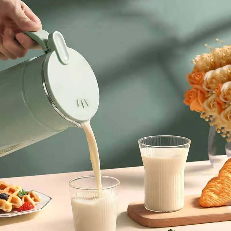 Hand pouring milk from a jug into a glass with breakfast foods, waffles, and flowers on table
