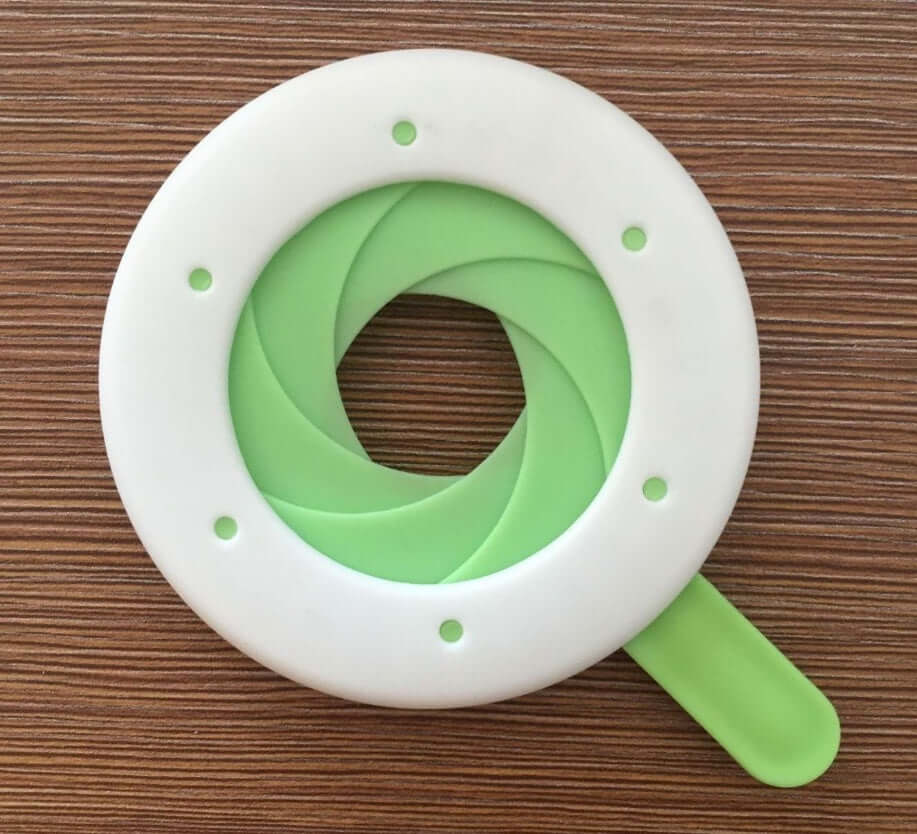Green and white silicone jar opener with twist grip on wood surface
