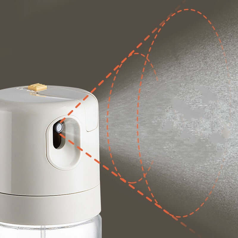 Close-up of a kitchen oil spray bottle releasing a fine mist for cooking