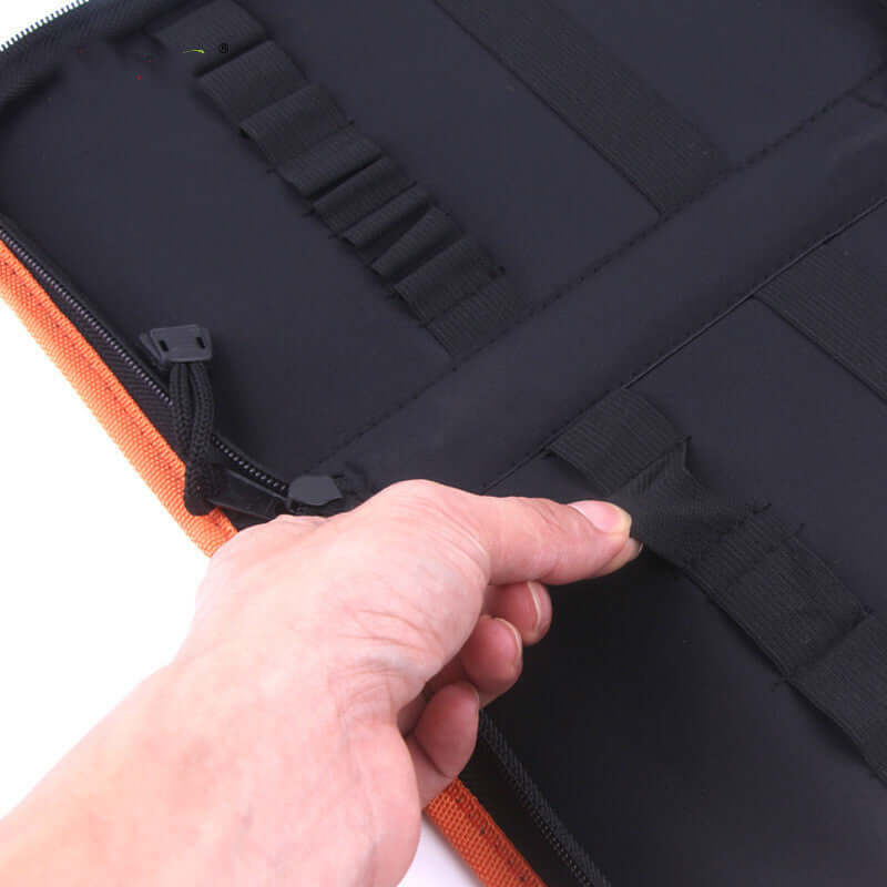 Hand opening a black kitchen utensil organizer case with elastic straps and zipper