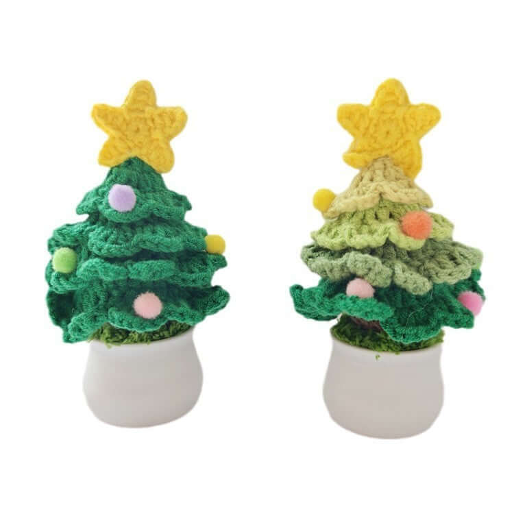 Two small crocheted Christmas tree decorations with yellow star toppers in white pots