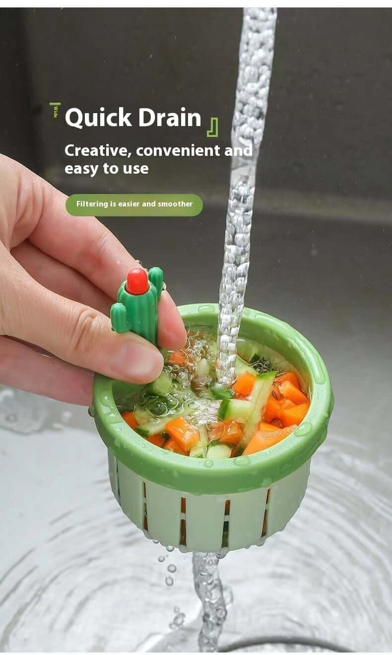 Hand holding green kitchen sink strainer with vegetables, water draining quickly under faucet