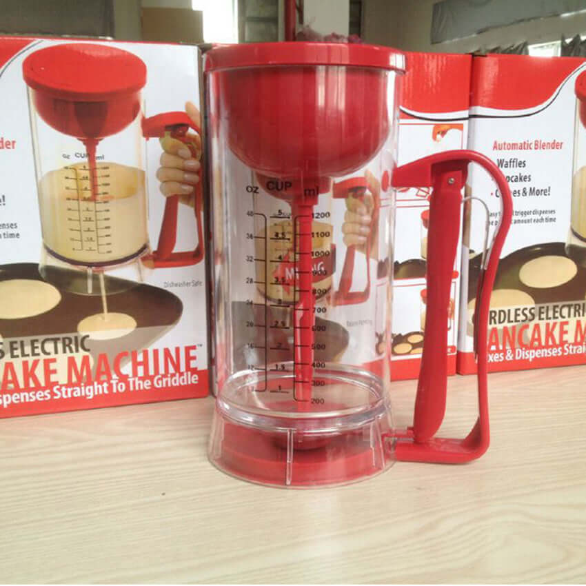 Red pancake batter dispenser with measuring lines for easy pouring on kitchen counter