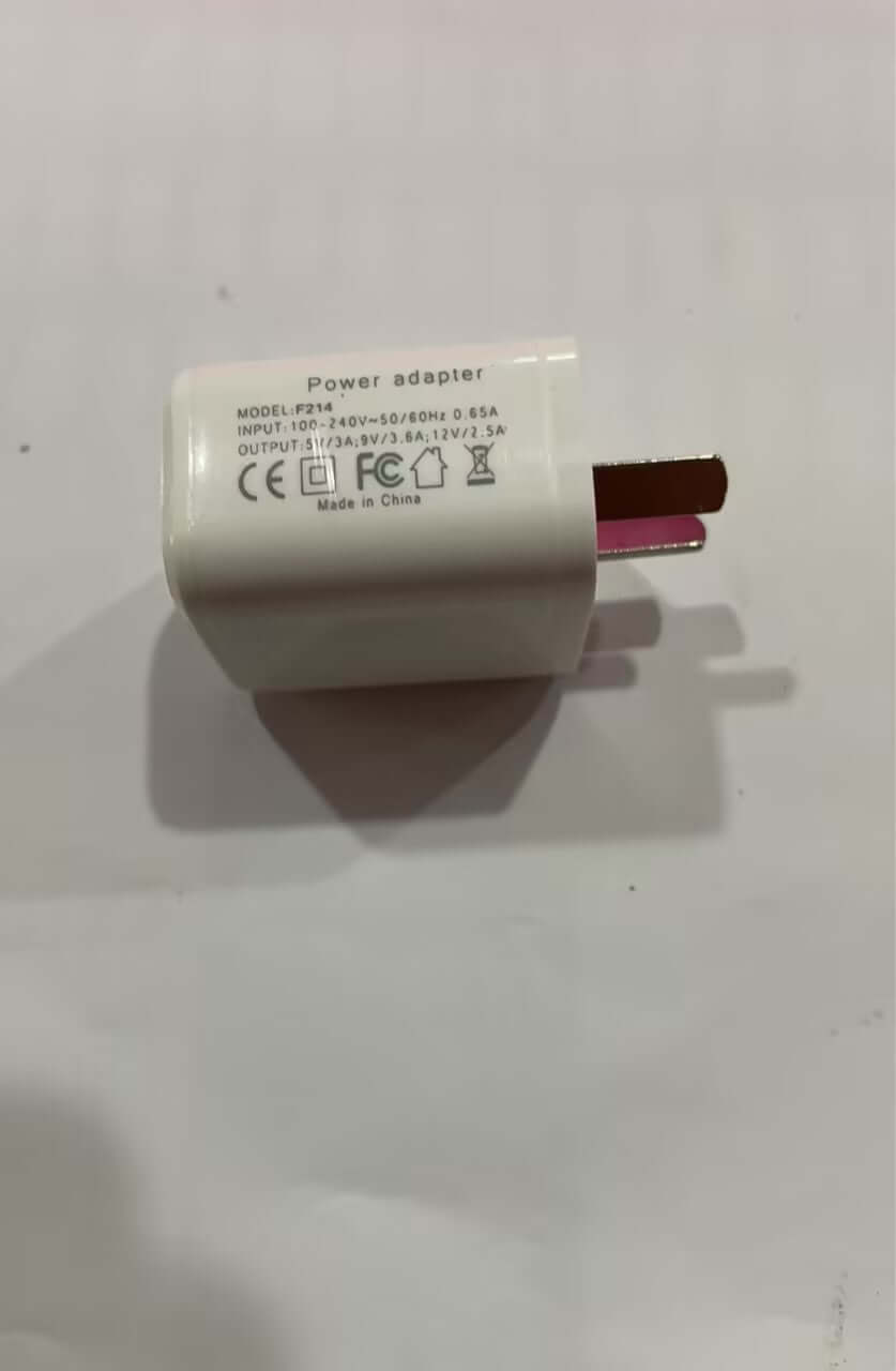 White universal power adapter with electrical plug and certification labels on white background