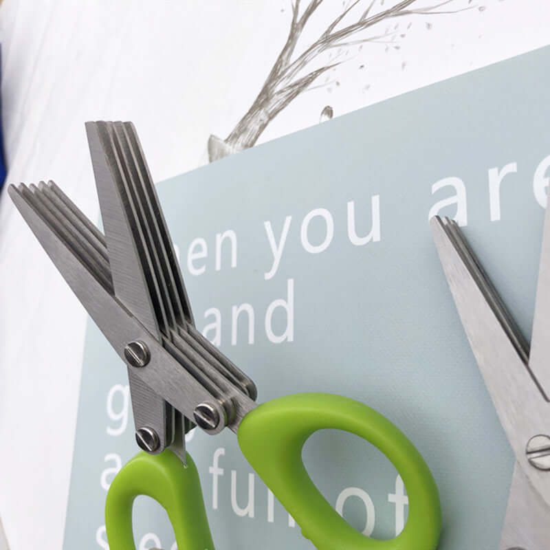 Multi-blade herb scissors with green handles on a kitchen surface