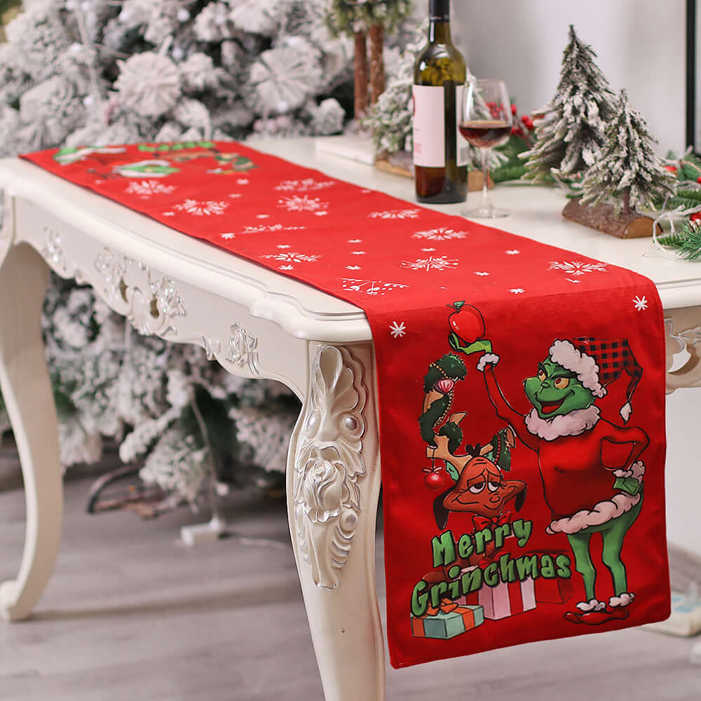 Christmas table runner with green character, red background, and snowflake pattern on dining table