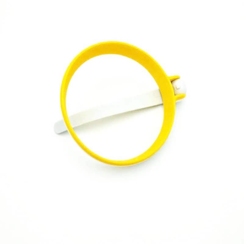 Yellow silicone egg ring kitchen accessory with handle on white background