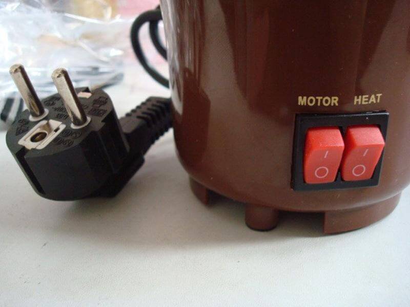 Close-up of kitchen appliance base with plug, motor and heat switches