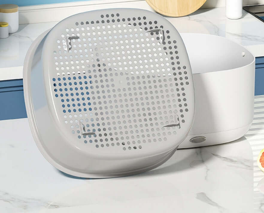 Plastic kitchen strainer basket with drain holes on a marble countertop