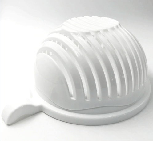 White plastic salad cutter bowl and slicer kitchen accessory on white background